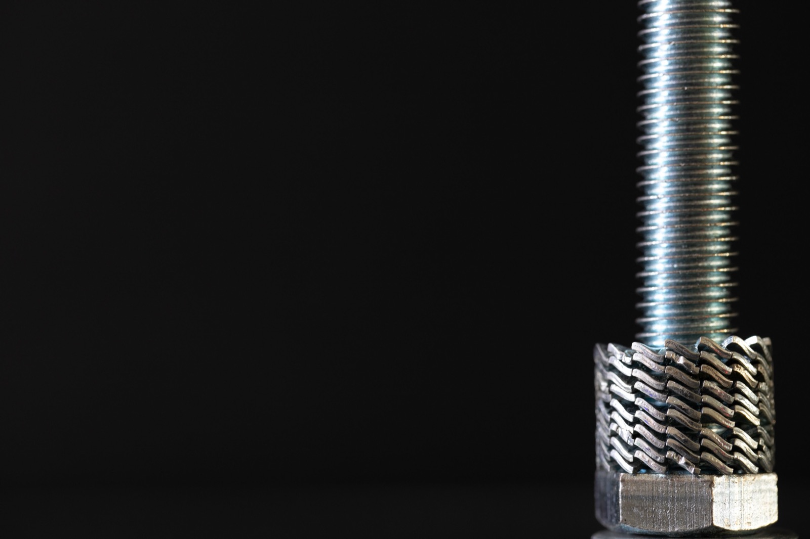Close-up of a threaded fastener with stacked nuts